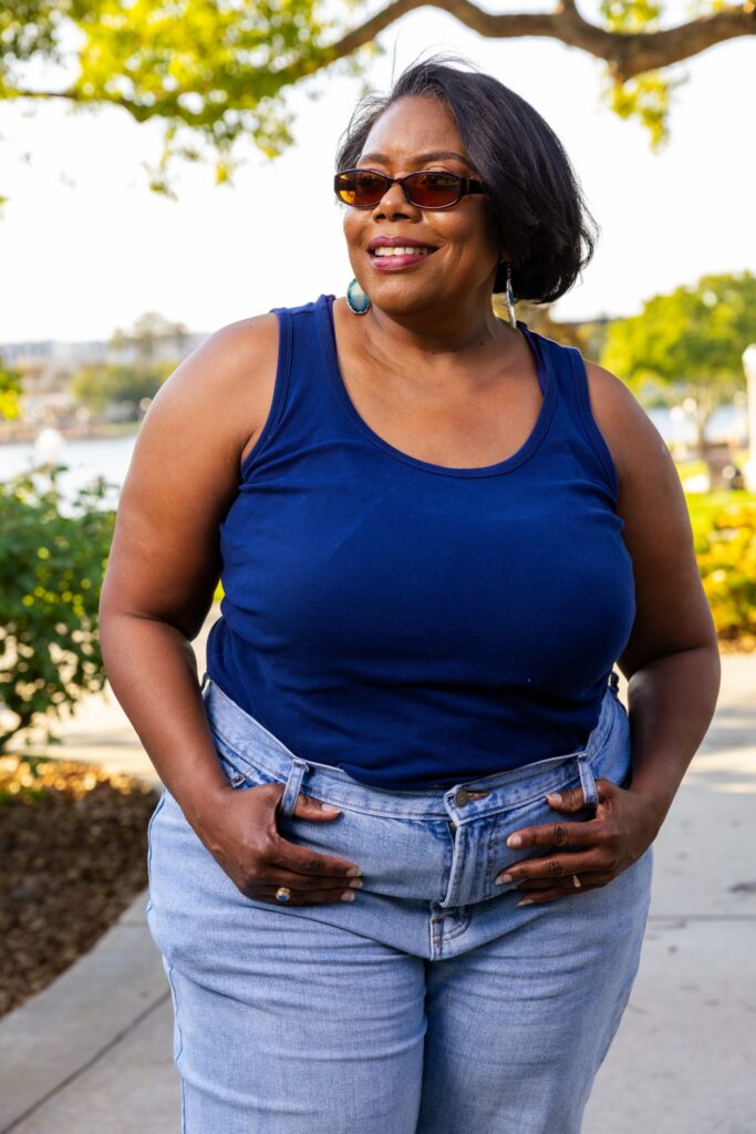 Author photo of Kristene Fields, a Black woman with short black hair and sunglasses, wearing a blue tank top and jeans.